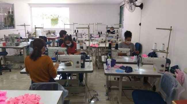 maquinas_costura Mulheres costuram em máquinas em sala de costura